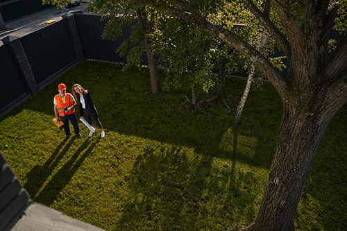 Homeowner and Smithville tree service professional inspecting yard